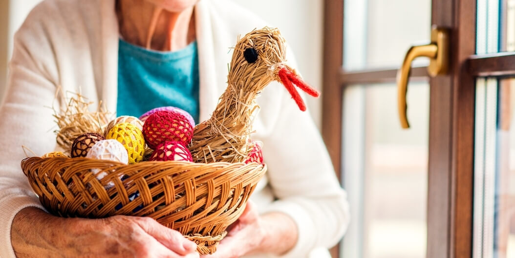 Elderly Woman Holding Basket of Holiday Crafts in Independent Living