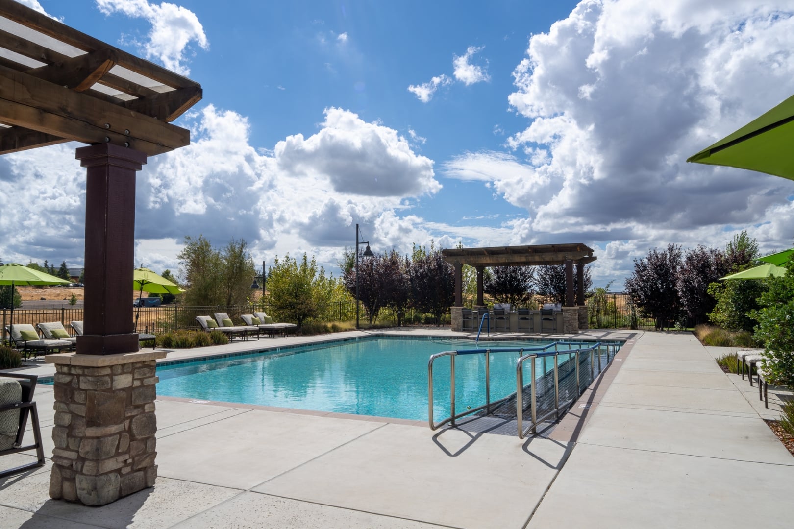 Outdoor Pool with Covered Pergola Seating at Independent Living Facility