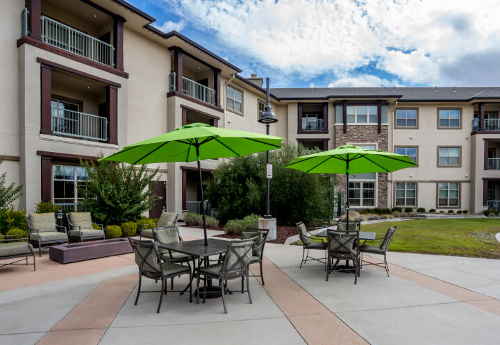 Outdoor Patio Seating with Umbrellas at Independent Living Facility Outdoor Patio Seating with Umbrellas at Independent Living Facility
